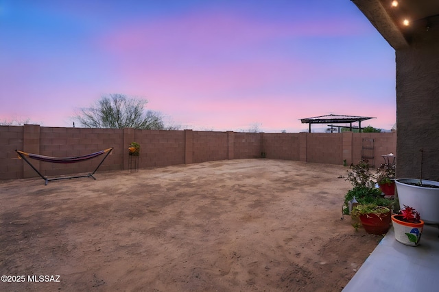 yard at dusk with a fenced backyard