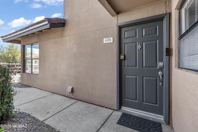 doorway to property featuring stucco siding