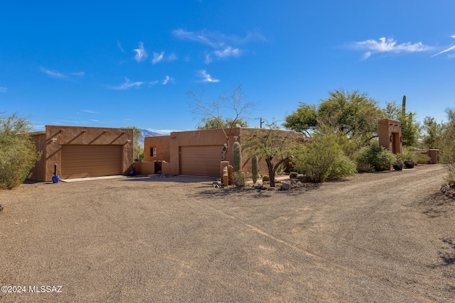 adobe home featuring a garage and stucco siding