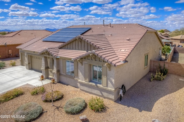 view of front of house featuring fence, driveway, an attached garage, stucco siding, and a tiled roof