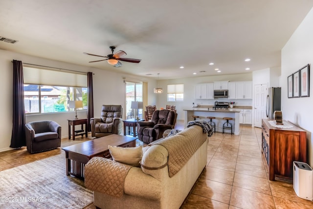 living area with visible vents, recessed lighting, light tile patterned floors, baseboards, and ceiling fan