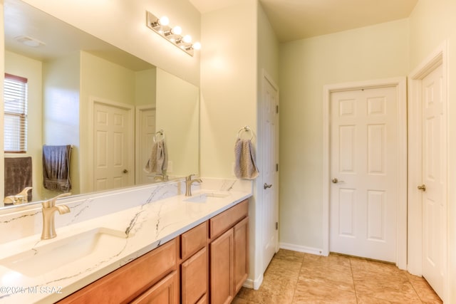 bathroom featuring double vanity, baseboards, and a sink