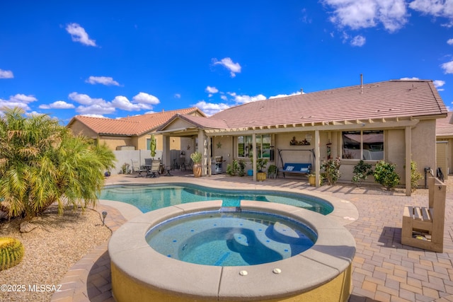 view of swimming pool with a patio, fence, and a pool with connected hot tub