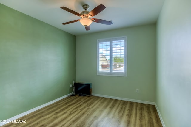 unfurnished room with ceiling fan, baseboards, and wood finished floors