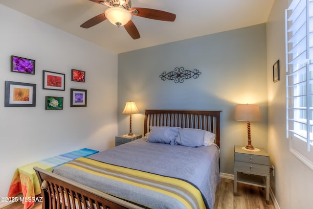 bedroom featuring wood finished floors, baseboards, and ceiling fan