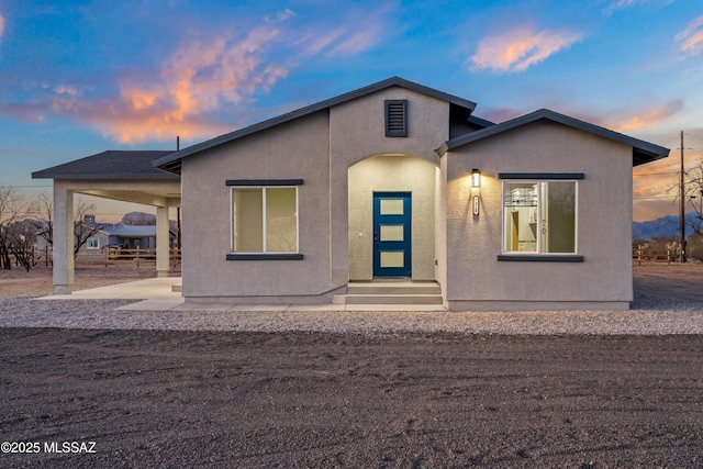 view of front facade with stucco siding and entry steps