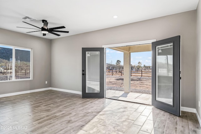 unfurnished room featuring french doors, visible vents, light wood finished floors, and baseboards