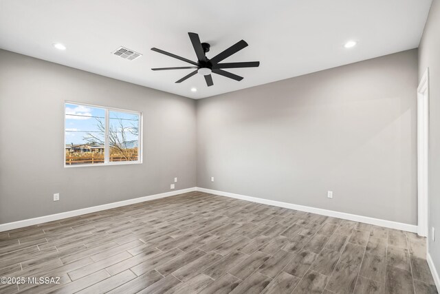 empty room with a ceiling fan, recessed lighting, wood finished floors, and baseboards