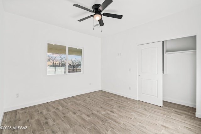 unfurnished bedroom featuring visible vents, baseboards, wood tiled floor, a closet, and a ceiling fan