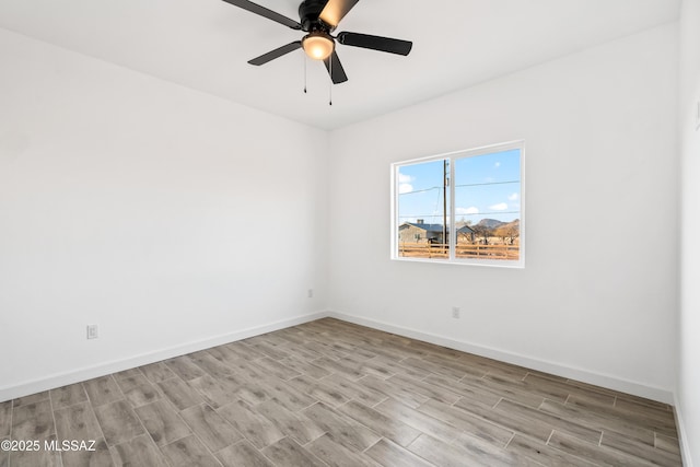 unfurnished room with a ceiling fan, light wood-style floors, and baseboards