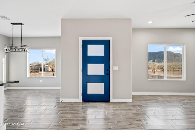 foyer featuring baseboards, visible vents, wood tiled floor, recessed lighting, and a notable chandelier