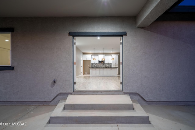 interior space featuring baseboards and a textured wall