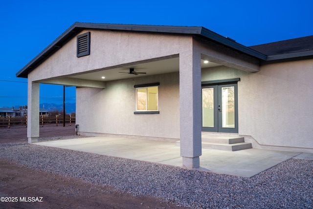 exterior space with a patio, stucco siding, french doors, and ceiling fan