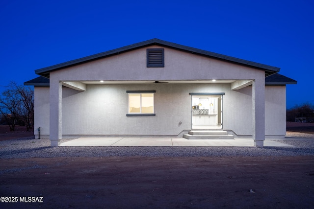 back of property featuring stucco siding