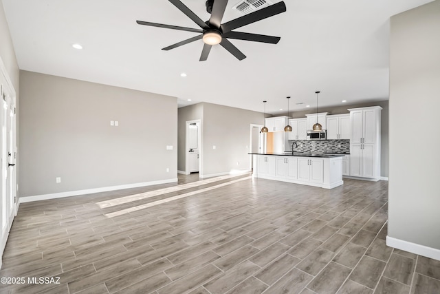 unfurnished living room featuring recessed lighting, baseboards, a ceiling fan, and light wood finished floors