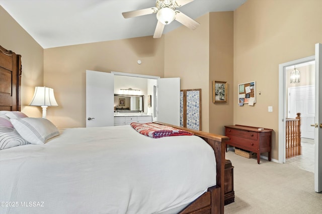 bedroom featuring high vaulted ceiling, ensuite bathroom, baseboards, light colored carpet, and ceiling fan