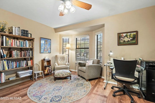 office space featuring ceiling fan, baseboards, and wood finished floors