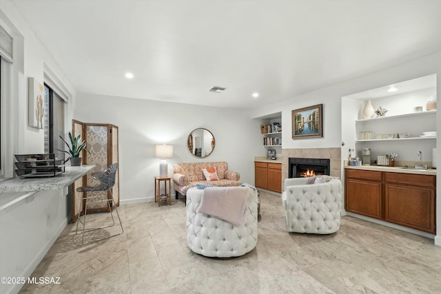 living room featuring visible vents, recessed lighting, a tile fireplace, and baseboards