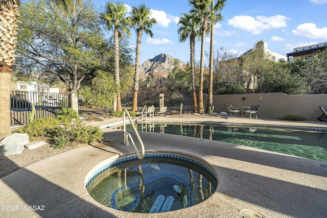 view of pool with a fenced in pool, a patio area, an in ground hot tub, and fence