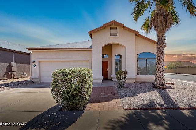 mediterranean / spanish home with a garage, driveway, and stucco siding