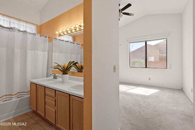 bathroom with a sink, ceiling fan, double vanity, and vaulted ceiling