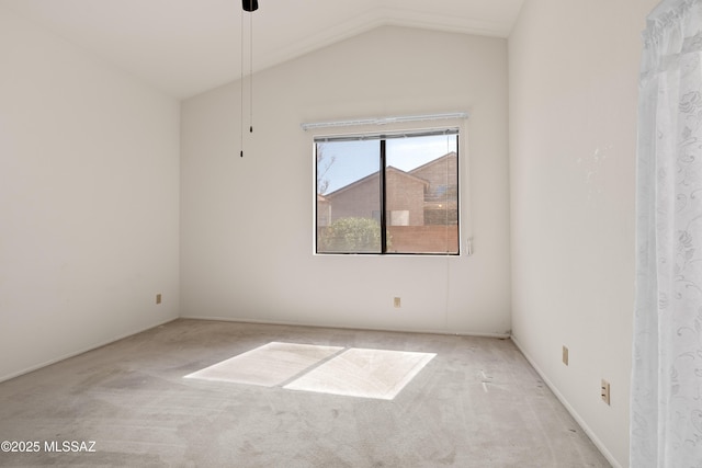 carpeted spare room featuring vaulted ceiling