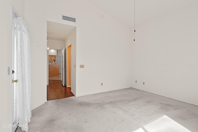 carpeted empty room featuring visible vents