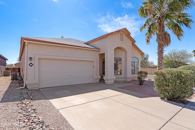 mediterranean / spanish-style home with central AC, stucco siding, concrete driveway, and a garage