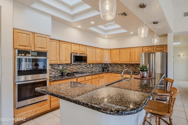 kitchen featuring backsplash, visible vents, appliances with stainless steel finishes, and a sink