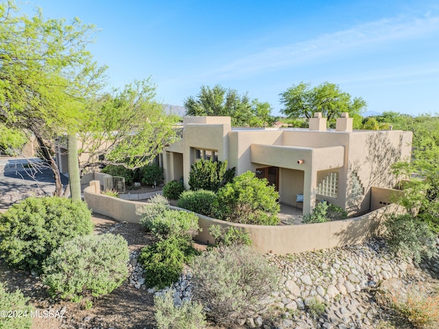 view of front of home featuring stucco siding and fence