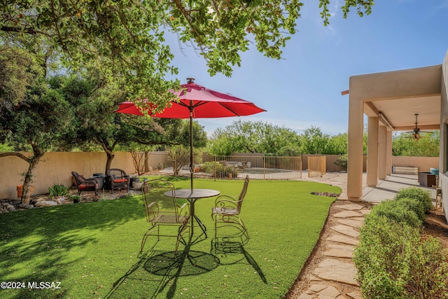 view of yard with a patio area, ceiling fan, and a fenced backyard