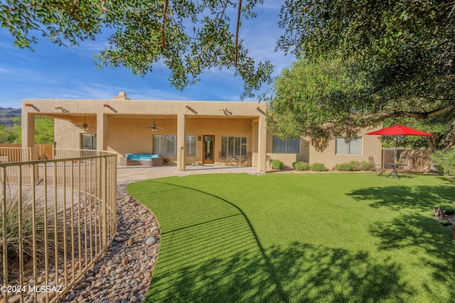 rear view of property featuring a patio area, stucco siding, a ceiling fan, and fence