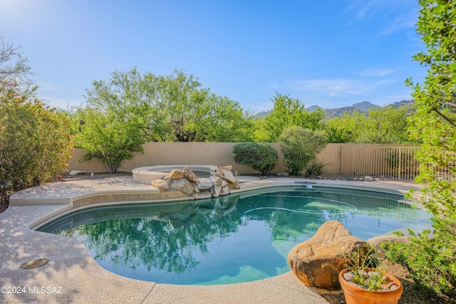 view of pool with a fenced in pool, an in ground hot tub, and a fenced backyard