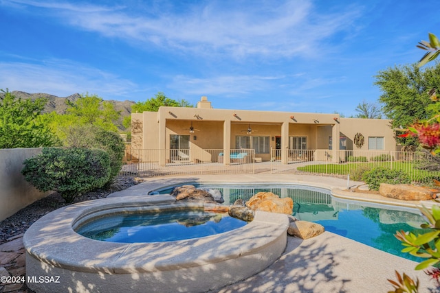 view of swimming pool with a patio, a ceiling fan, fence, a fenced in pool, and an in ground hot tub