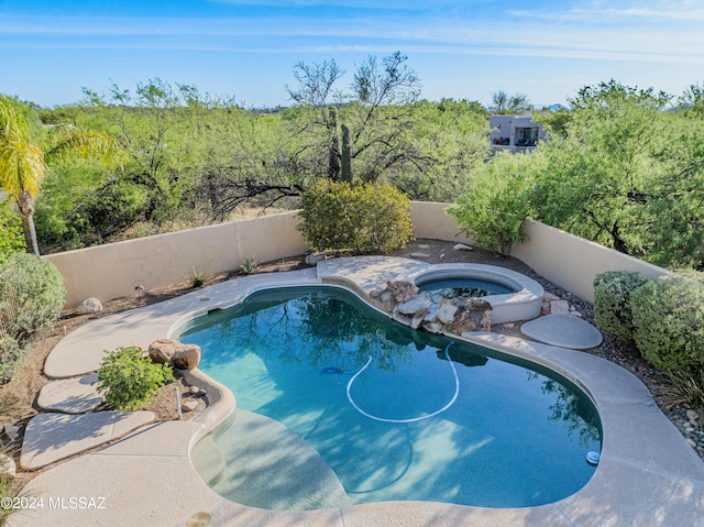 view of swimming pool with a fenced in pool, an in ground hot tub, and a fenced backyard