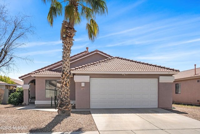 view of front facade with stucco siding, an attached garage, and concrete driveway