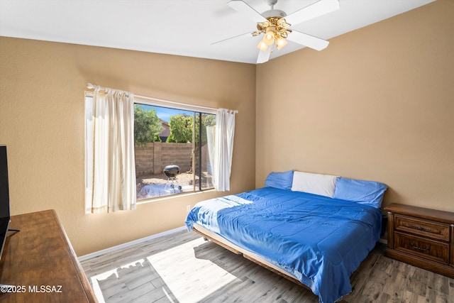 bedroom with ceiling fan, baseboards, and wood finished floors