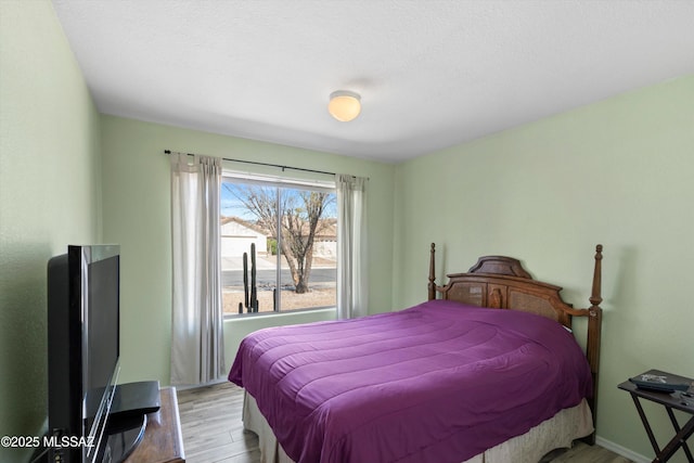 bedroom featuring baseboards and wood finished floors