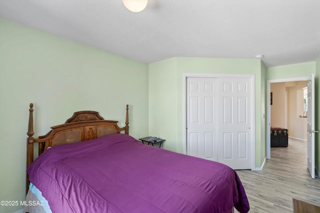 bedroom featuring baseboards, a closet, and light wood-type flooring