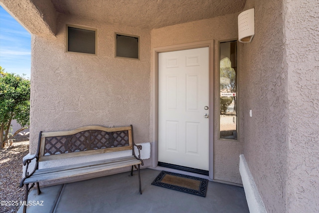 entrance to property featuring stucco siding