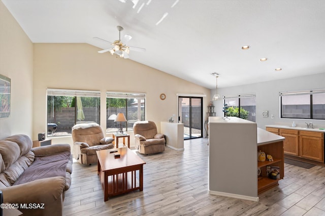 living area with recessed lighting, light wood-style floors, and vaulted ceiling