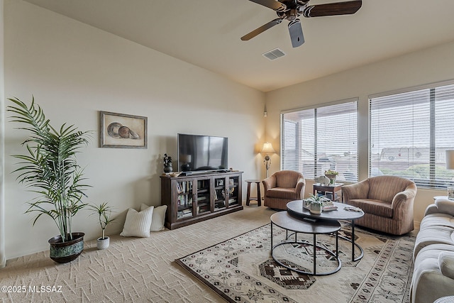 living area with visible vents, ceiling fan, plenty of natural light, and lofted ceiling