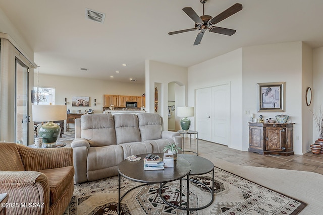 living area featuring visible vents, recessed lighting, arched walkways, light tile patterned floors, and ceiling fan