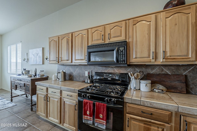 kitchen with decorative backsplash, black appliances, tile counters, and light brown cabinets