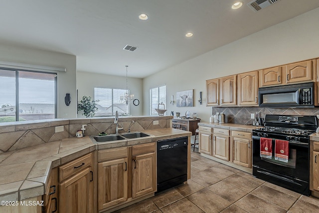 kitchen featuring visible vents, tile countertops, black appliances, and a sink