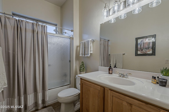 bathroom featuring vanity, toilet, and bath / shower combo with glass door