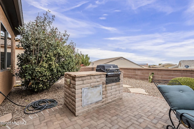 view of patio with area for grilling and fence