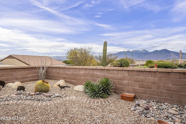 view of yard featuring a mountain view and fence