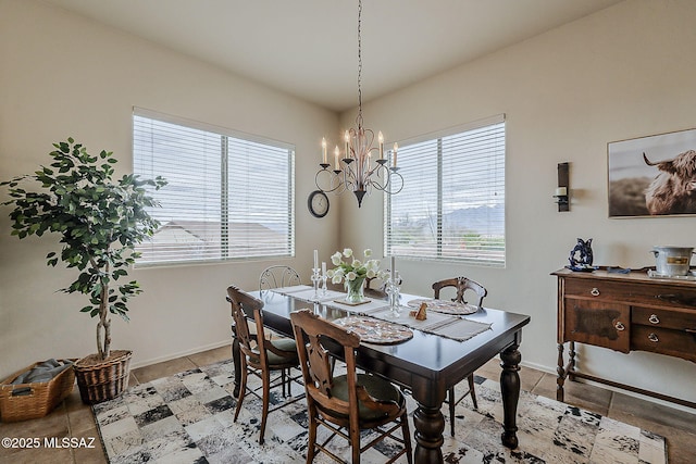 dining area with light tile patterned floors, baseboards, and a chandelier