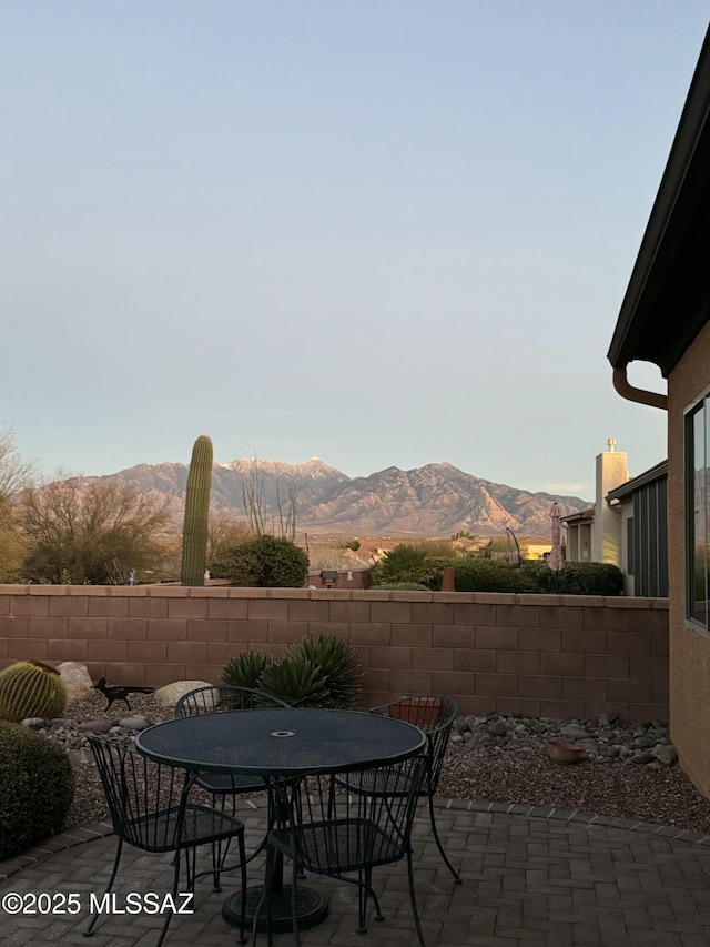 view of patio / terrace with a mountain view, outdoor dining space, and fence